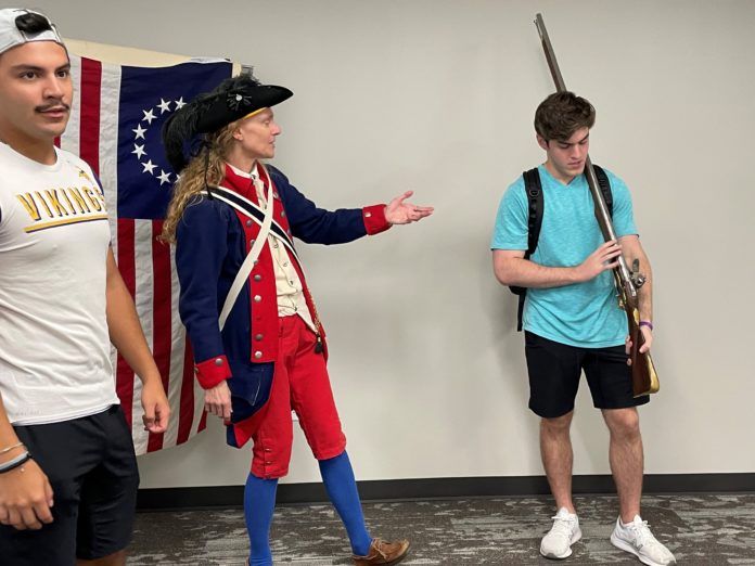 faculty teaching student wearing american revolution regalia