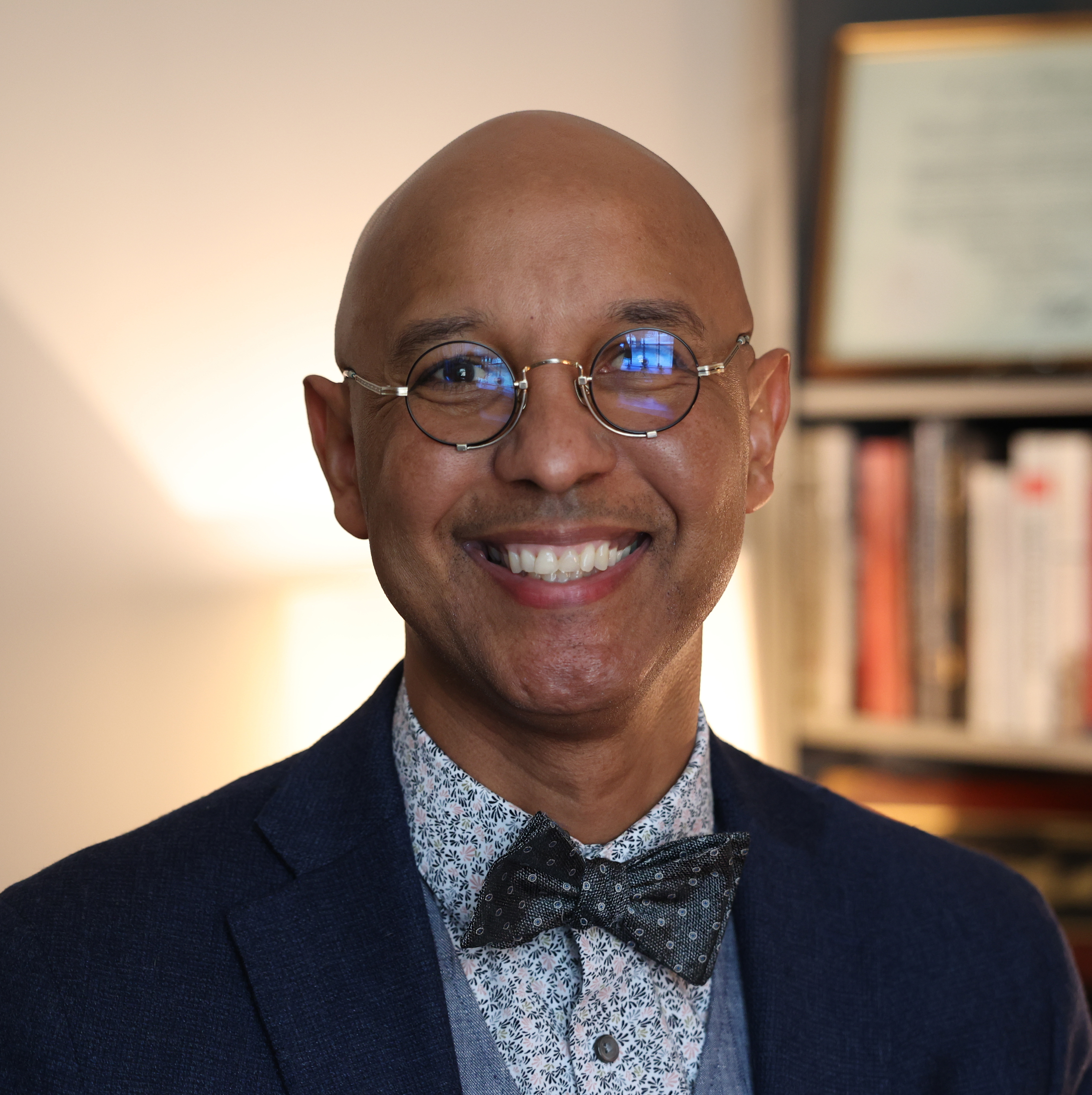 man in office with glasses smiling