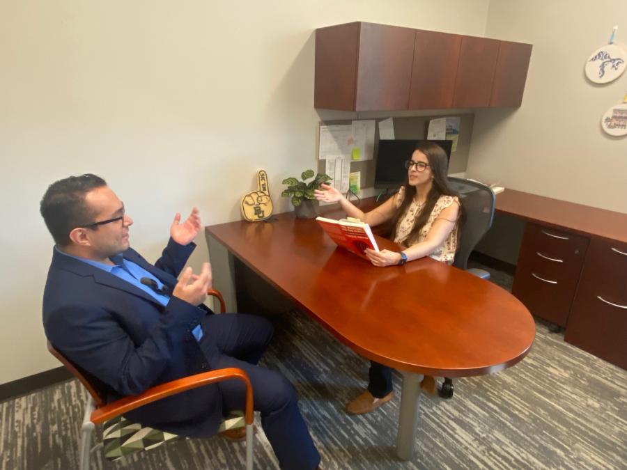 two faculty in talking in the office