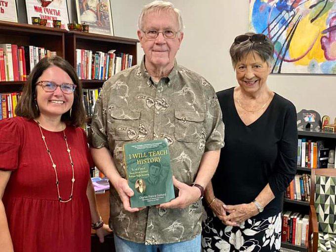 man holding book with two ladies