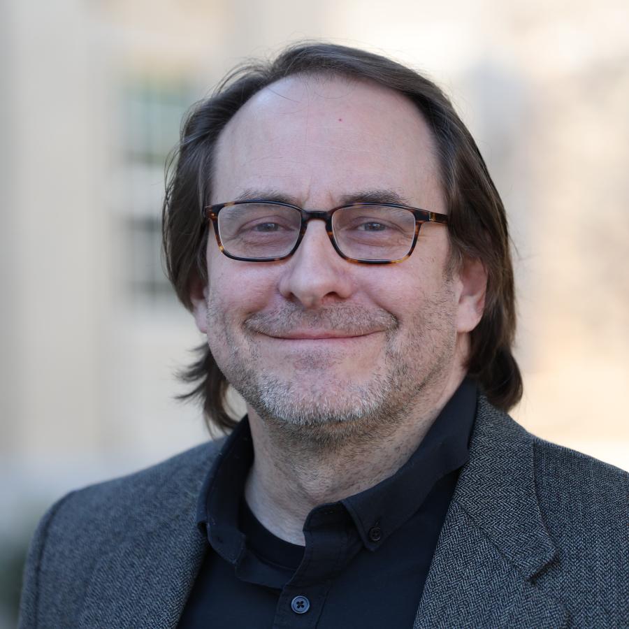 Man wearing glasses smiling at camera