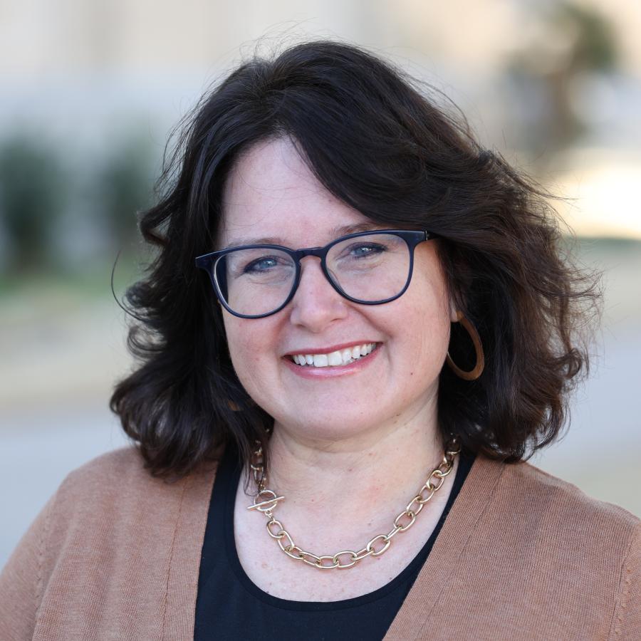 woman in glasses smiling at camera