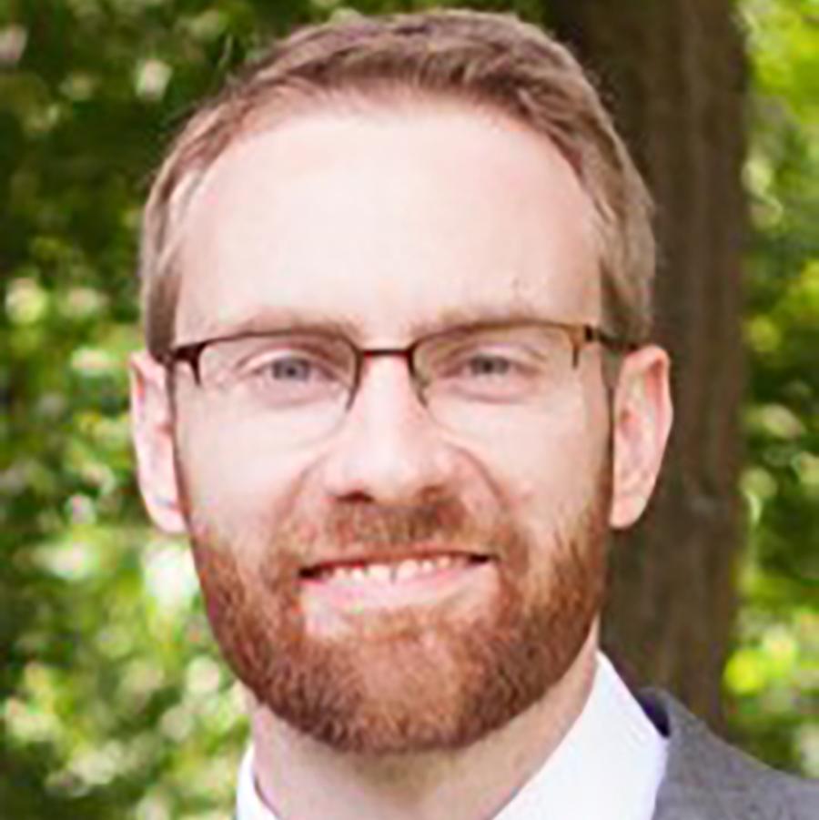 man in glasses smiling at camera