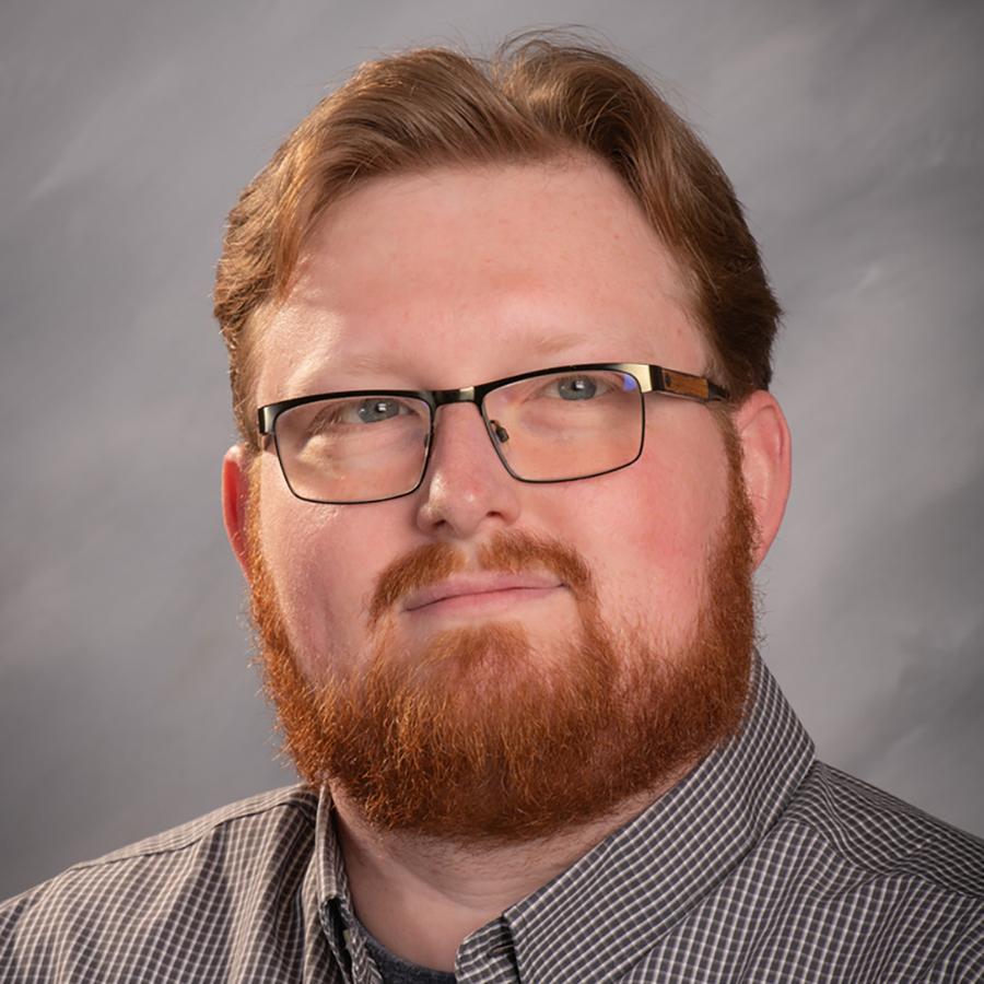 man in glasses smiling at camera