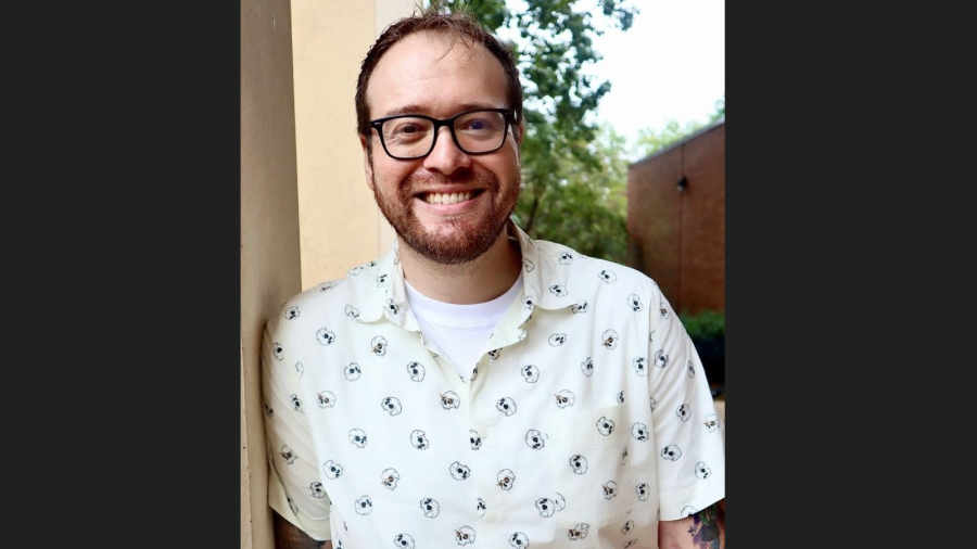 man wearing glasses smiling at camera