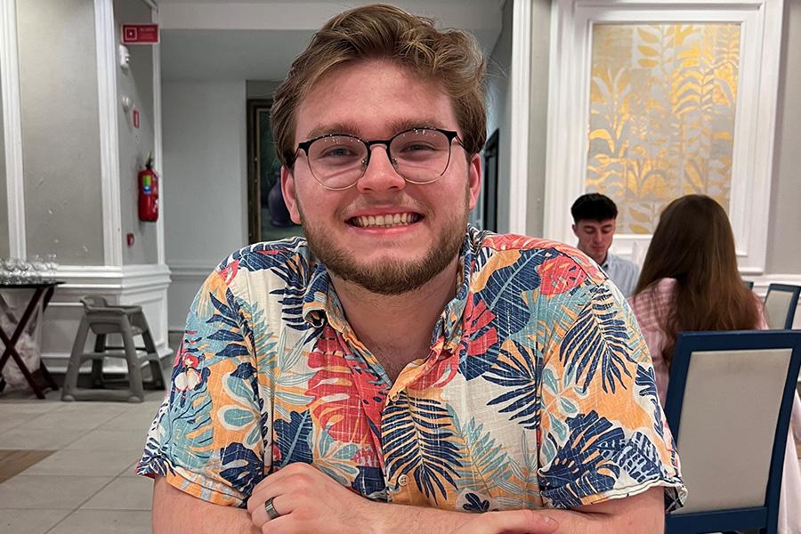 Headshot of Gabe Creech wearing colorful collared shirt and smiling at the camera