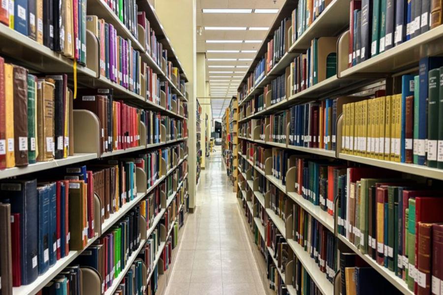 shelves of books line a library hallway on either side.