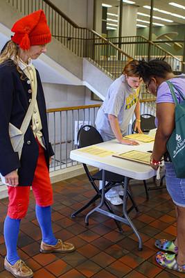 Dr. Sweet assists students in making historical presidential campaign buttons wearing American Revolutionary War uniform