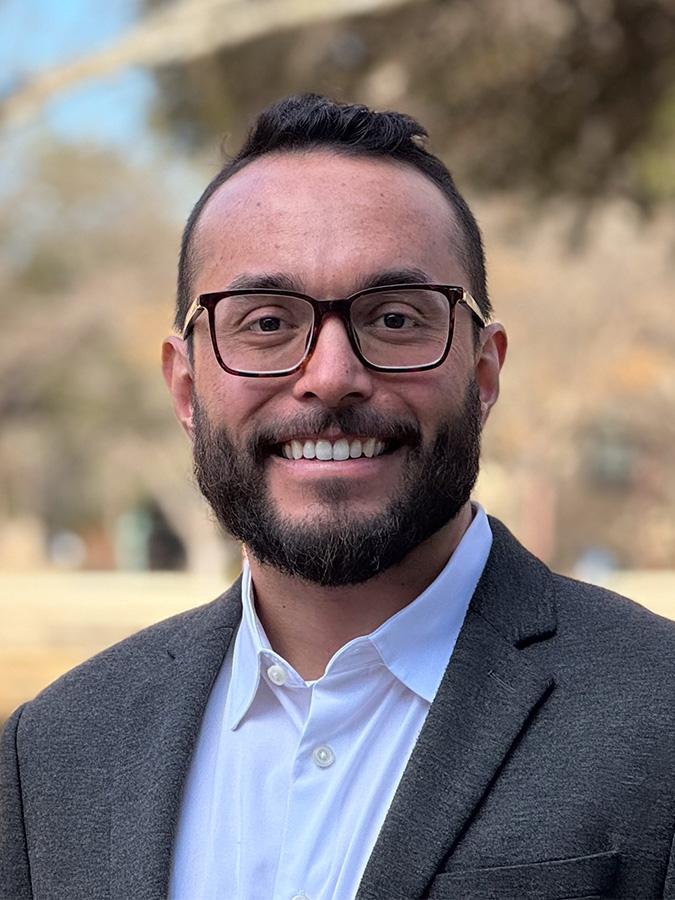 man in glasses smiling at camera