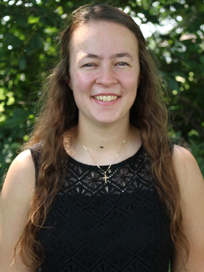 Tori Ritzma wears a black sleeveless shirt and smiles at the camera.